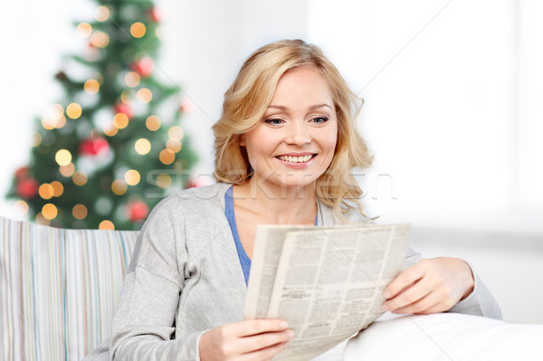 smiling woman reading newspaper at christmas Stock photo © dolgachov