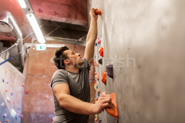 young man exercising at indoor climbing gym Stock photo © dolgachov