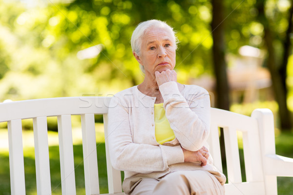 sad senior woman sitting on bench at summer park Stock photo © dolgachov