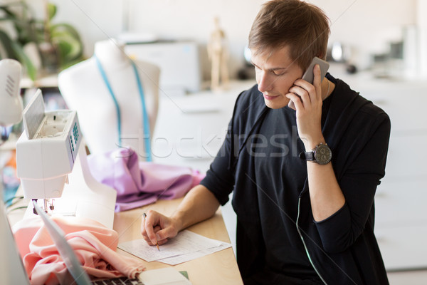 fashion designer calling on smartphone at studio Stock photo © dolgachov