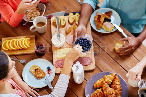 people having breakfast at table with food Stock photo © dolgachov