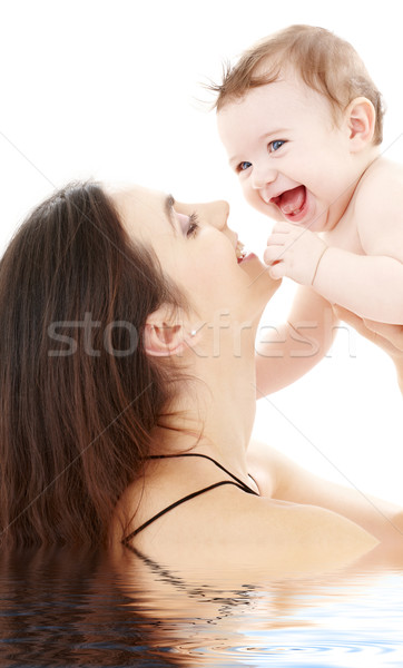Stock photo: laughing blue-eyed baby playing with mom
