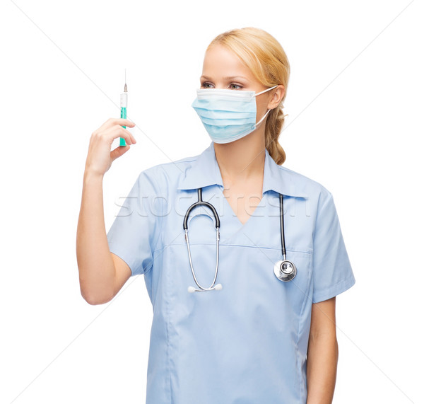 Stock photo: female doctor or nurse in mask holding syringe