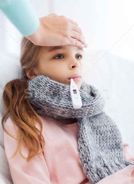 ill girl child with thermometer and caring mother Stock photo © dolgachov