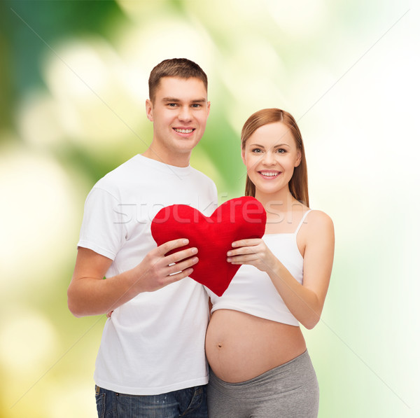 Stock photo: happy young family expecting child with big heart