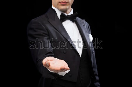 magician holding something on palm of his hand Stock photo © dolgachov