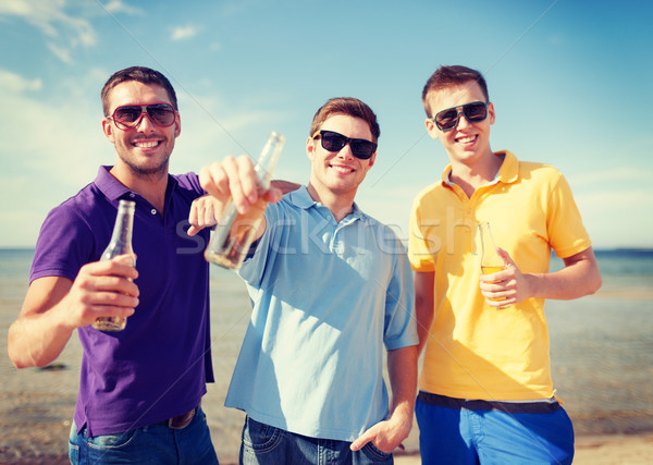 group of male friends with bottles of beer Stock photo © dolgachov