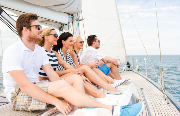 smiling friends sitting on yacht deck Stock photo © dolgachov