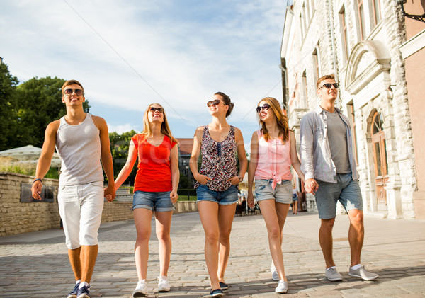 group of smiling friends walking in city Stock photo © dolgachov