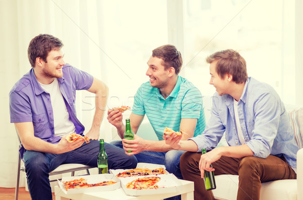 Glimlachend vrienden bier pizza opknoping uit Stockfoto © dolgachov