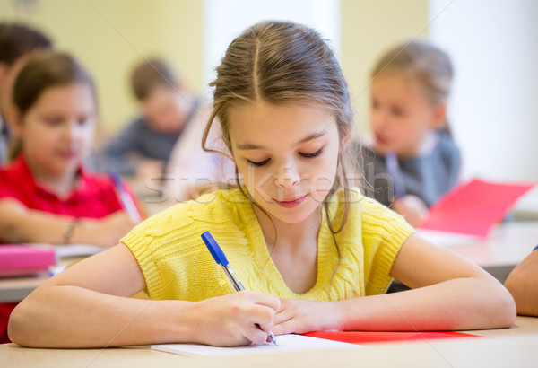 group of school kids writing test in classroom Stock photo © dolgachov