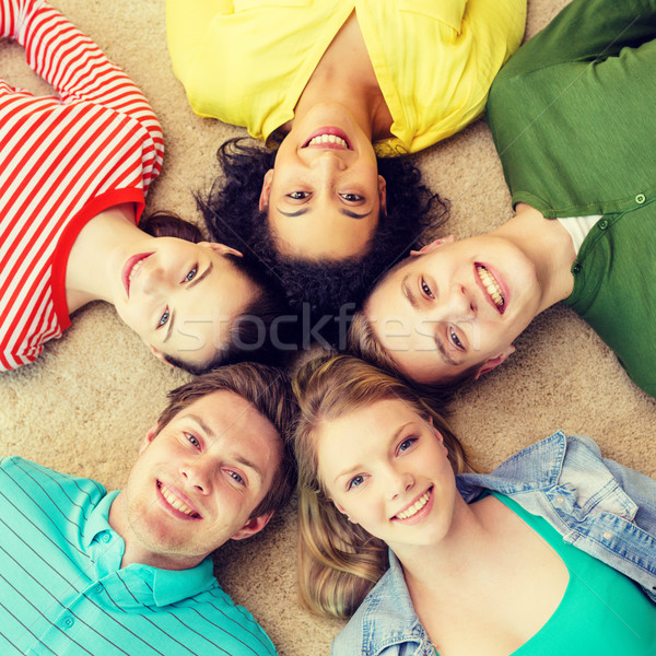 group of smiling people lying down on floor Stock photo © dolgachov