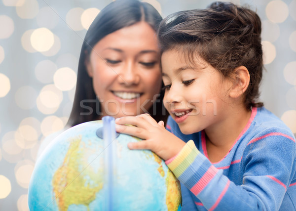happy mother and daughter with globe Stock photo © dolgachov