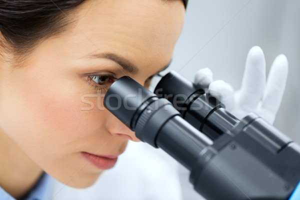 close up of scientist looking to microscope in lab Stock photo © dolgachov