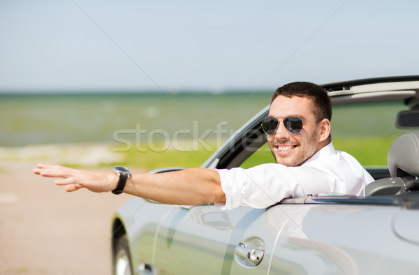 happy man driving cabriolet car and waving hand Stock photo © dolgachov