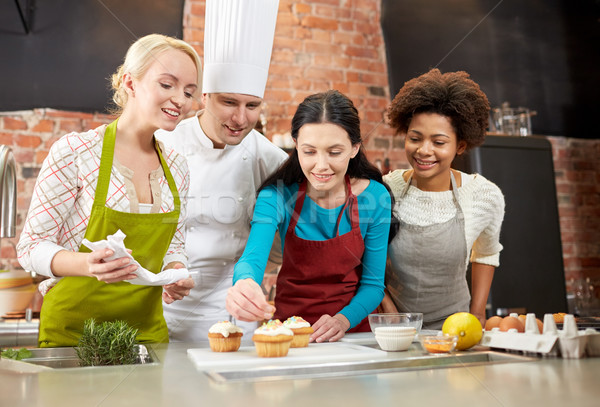 happy women and chef cook baking in kitchen Stock photo © dolgachov