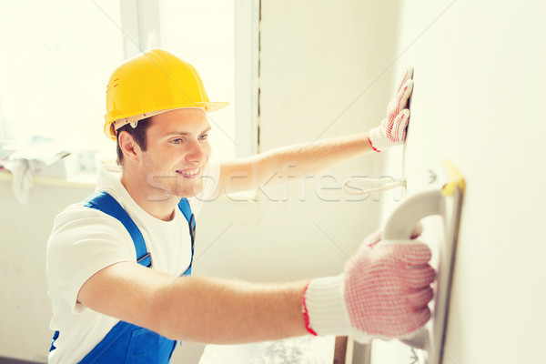 smiling builder with grinding tool indoors Stock photo © dolgachov