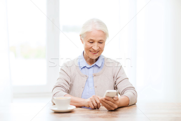 senior woman with smartphone texting at home Stock photo © dolgachov