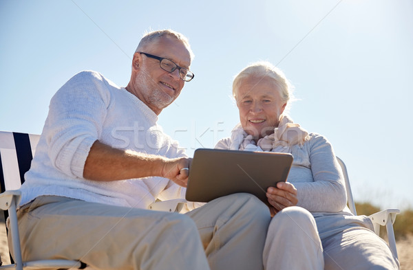 happy senior couple with tablet pc on summer beach Stock photo © dolgachov