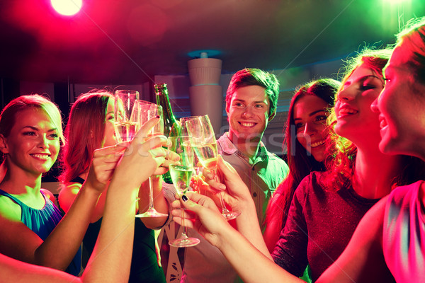 smiling friends with wine glasses and beer in club Stock photo © dolgachov