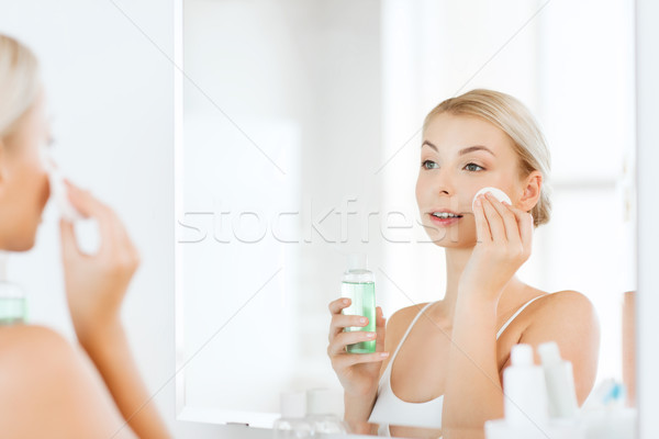 young woman with lotion washing face at bathroom Stock photo © dolgachov