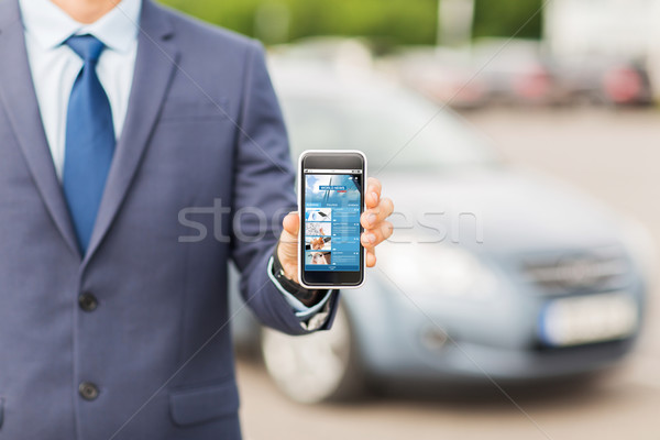 Stock photo: close up of business man with smartphone and car