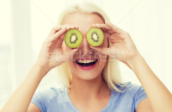 happy woman having fun covering eyes with kiwi Stock photo © dolgachov