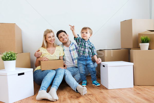 happy family with boxes moving to new home Stock photo © dolgachov