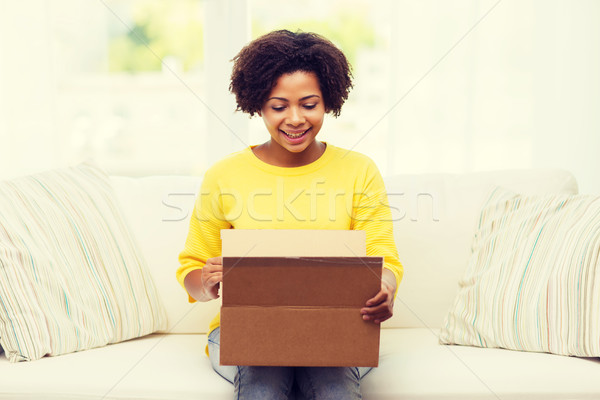 happy african young woman with parcel box at home Stock photo © dolgachov