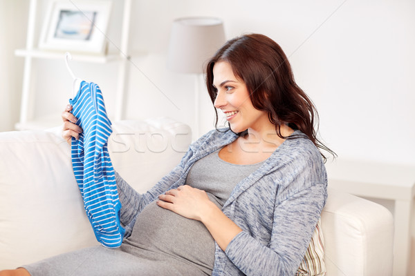 happy woman holding baby boys bodysuit at home Stock photo © dolgachov