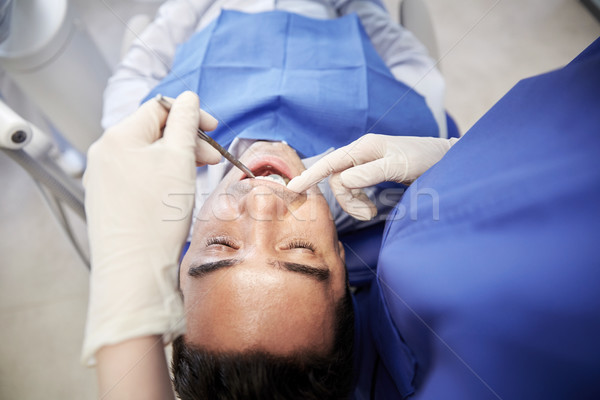 close up of dentist checking male patient teeth Stock photo © dolgachov