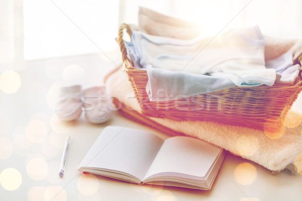 close up of baby clothes for newborn and notebook Stock photo © dolgachov