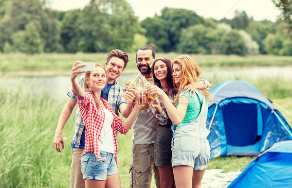 happy friends taking selfie by smartphone at camp Stock photo © dolgachov