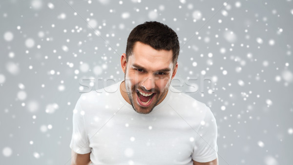 angry man shouting over snow background Stock photo © dolgachov
