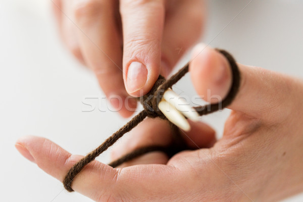 Stock photo: close up of hands knitting with needles and yarn