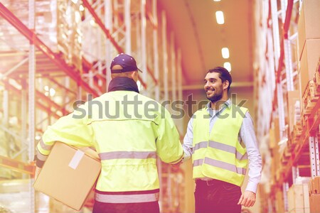 men in safety vests shaking hands at warehouse Stock photo © dolgachov