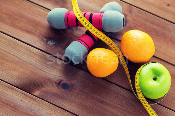 close up of dumbbell, fruits and measuring tape Stock photo © dolgachov