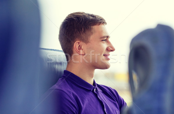 happy young man sitting in travel bus Stock photo © dolgachov