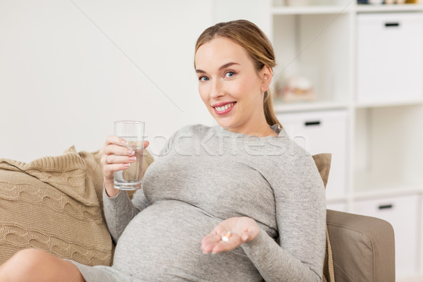 Felice donna incinta acqua pillole home gravidanza Foto d'archivio © dolgachov