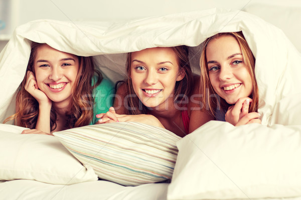 happy young women in bed at home pajama party Stock photo © dolgachov