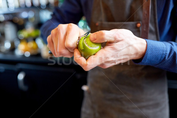 bartender removing peel from lime at bar Stock photo © dolgachov