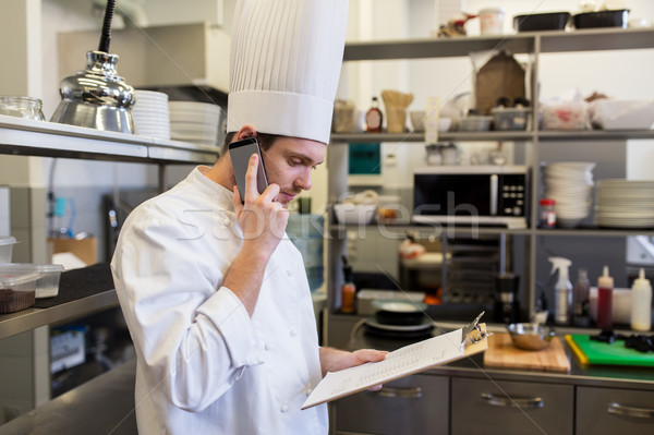 chef cook calling on smartphone at restaurant kitchen Stock photo © dolgachov