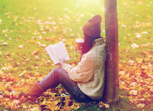 woman with book drinking coffee in autumn park Stock photo © dolgachov