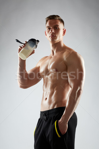 young man or bodybuilder with protein shake bottle Stock photo © dolgachov