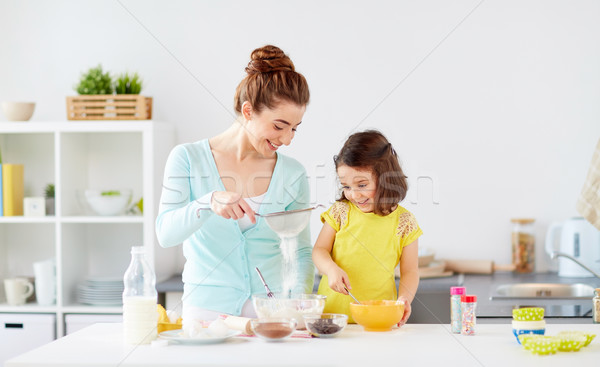 happy mother and daughter baking at home Stock photo © dolgachov