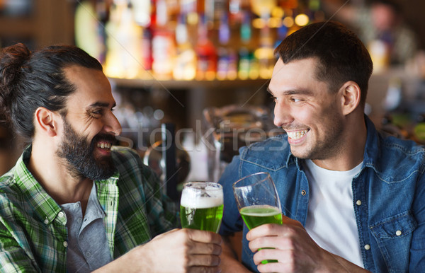 male friends drinking green beer at bar or pub Stock photo © dolgachov