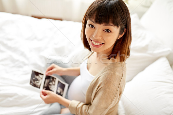 pregnant woman with fetal ultrasound image at home Stock photo © dolgachov