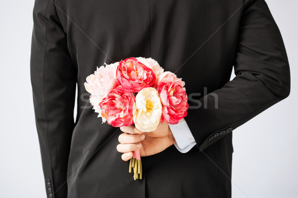 man hiding bouquet of flowers Stock photo © dolgachov