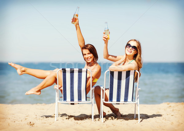Stock photo: girls sunbathing on the beach chairs