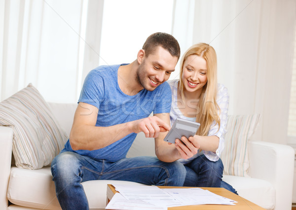 smiling couple with papers and calculator at home Stock photo © dolgachov